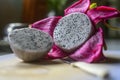 Two halves of Dragon fruit on a wooden cutting board with a small knife. peeled off and cut into two pieces in the home kitchen.