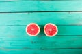Two halves of grapefruit on a wooden turquoise background Royalty Free Stock Photo