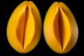 Two halves of mango on black background. Generative AI Royalty Free Stock Photo