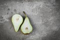 Halves of the pear on gray concrete background