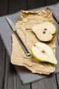 Two halves of pear on gray napkin. Kitchen knife