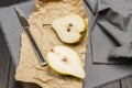 Two halves of pear on paper and gray napkin