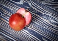 Two halves of a red apple are on a wooden surface
