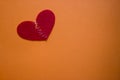 The two halves of the red heart of the fabric connect with a white thread on an orange background. the concept of sadness, unrequi Royalty Free Stock Photo