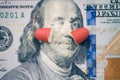 The two halves of the red pill lie on the Ben Franklin`s face of hundred-dollar bill.