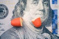 The two halves of the red pill lie on the Ben Franklin`s face of hundred-dollar bill.