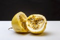 Two Halves Of A Yellow Passion Fruit On A White Surface With The Juicy Pulp