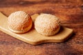 Two hamburger buns. Sesame seeds on top. Wooden background. Food concept Royalty Free Stock Photo