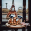 Two french patriotic hamster mice sitting at a table with a view of the eiffel tower. Generative AI image.