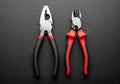 Two hand tools displayed on a dark surface: a combination plier on the left and a diagonal cutter Royalty Free Stock Photo