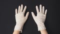 Two hand wear white latex gloves on black background