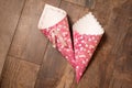 Two handmade paper cornets on wood background