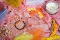 Two handmade shamballa bracelets on a pink tissue with scattered beads and orange cotton threads