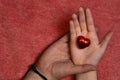 two hands adult and child hand, child holding a red heart chocolate Royalty Free Stock Photo