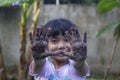 Two hands of Asian little girl dirty from the soil after planting a tree. Royalty Free Stock Photo