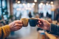 Two hands clinking coffee cups in a cozy cafe. A moment of connection and warmth captured in this inviting space. Enjoy the simple Royalty Free Stock Photo