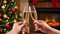 Christmas toast with two people clinking champagne glasses in front of decorated tree and fireplace. Cozy festive celebration Royalty Free Stock Photo