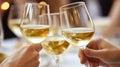 Two hands clinking glasses of white wine in celebration Royalty Free Stock Photo