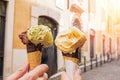 Two hands close-up holding cones with italian ice-cream gelato on the background of Rome streeet Royalty Free Stock Photo