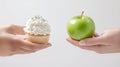 Two hands compare cupcake and green apple: diet choice concept Royalty Free Stock Photo