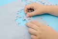 Two hands connecting puzzles on blue.wooden puzzle Teamwork, partnership, business idea, cooperation management concept