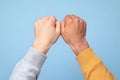 Person Fist Bumping with Diverse Skin Tones Against a Blue Background Showing Unity Royalty Free Stock Photo