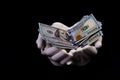 two hands with dollars. Closeup female hand giving money for something with isolated on black background,count, paying, shopping Royalty Free Stock Photo