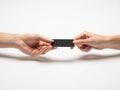 Two hands exchanging a black rectangle object isolated on white background Royalty Free Stock Photo
