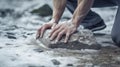 Two hands attempt to lift large stone from floor.AI Generated