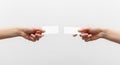Two human hands holding blank white rectangular cards against a plain light gray background for exchange or presentation Royalty Free Stock Photo