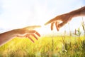 Two hands with fingers that almost touch in field Royalty Free Stock Photo