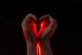 Two hands folded in the shape of a heart, light inside. Clench your hands, symbol of love. Royalty Free Stock Photo