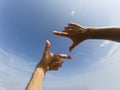 Two hands form a frame in front of a blue sky Royalty Free Stock Photo