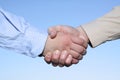 Two hands handshake isolated on sky background