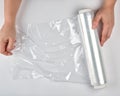 two hands hold a large roll of wound white transparent film for wrapping food Royalty Free Stock Photo