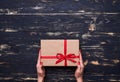 Two hands hold a nice gift box tied with red ribbon Royalty Free Stock Photo