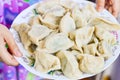 Two Hands Hold a Plate of Boiled Chinese Dumplings Jiaozi