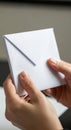 Two hands hold a white envelope with a triangular flap. The envelope is made of Royalty Free Stock Photo