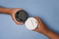 Two hands holding coffee on blue background. Royalty Free Stock Photo