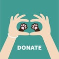 Two hands holding cute cat dog paw print. Love and care pet animals. Helping hand concept. Donate text. Flat design. Green