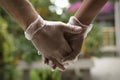 Two hands holding each other wearing sanitary gloves. Close up Royalty Free Stock Photo