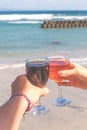 Two hands holding glasses with wine on sea background. Female and male hands with wine glasses. Royalty Free Stock Photo