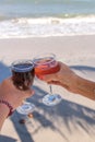 Two hands holding glasses with wine on sea background. Female and male hands with wine glasses. Royalty Free Stock Photo