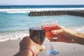 Two hands holding glasses with wine on sea background. Female and male hands with wine glasses. Royalty Free Stock Photo