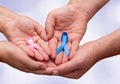 Two hands holding two Pink and Blue ribbons for the Pink October and Blue November campaigns to support life and raise awareness