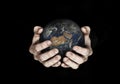 Two hands holding planet Earth isolated on black. Elements of this image furnished by NASA. Royalty Free Stock Photo