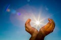 Two hands holding the sun on a blue sky background Royalty Free Stock Photo