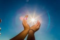 Two hands holding the sun on a blue sky background Royalty Free Stock Photo