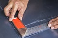 Two hands keep metal angle on steel plate. Royalty Free Stock Photo
