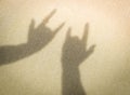 Two hands making shadow of I Love You sign on sand at the beach. Royalty Free Stock Photo